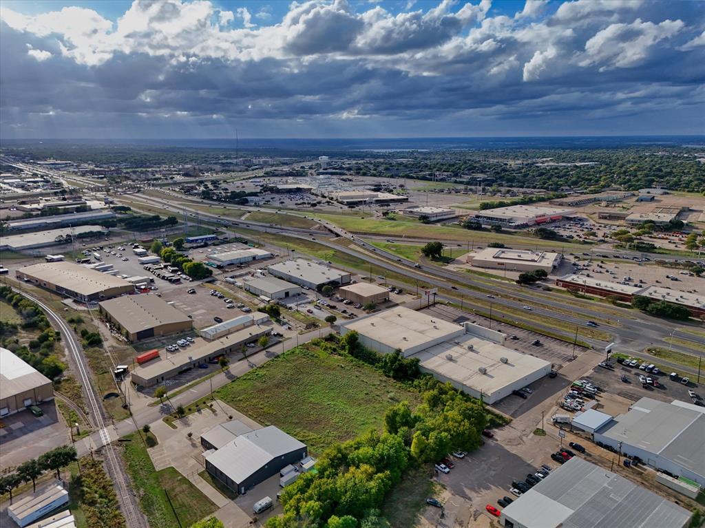 Aerial perspective showcasing a parcel of land in an industrial district with multi-lane highway frontage and rail line access