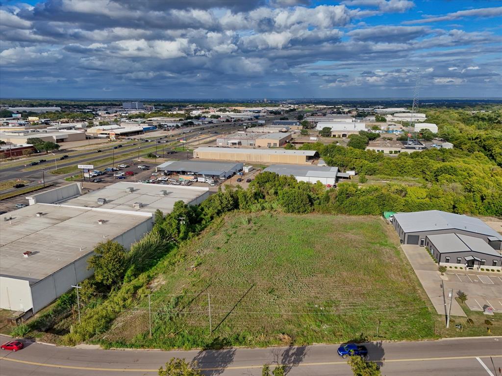 Vacant lot featuring cleared terrain, proximity to established industrial infrastructure, and direct asphalt street frontage