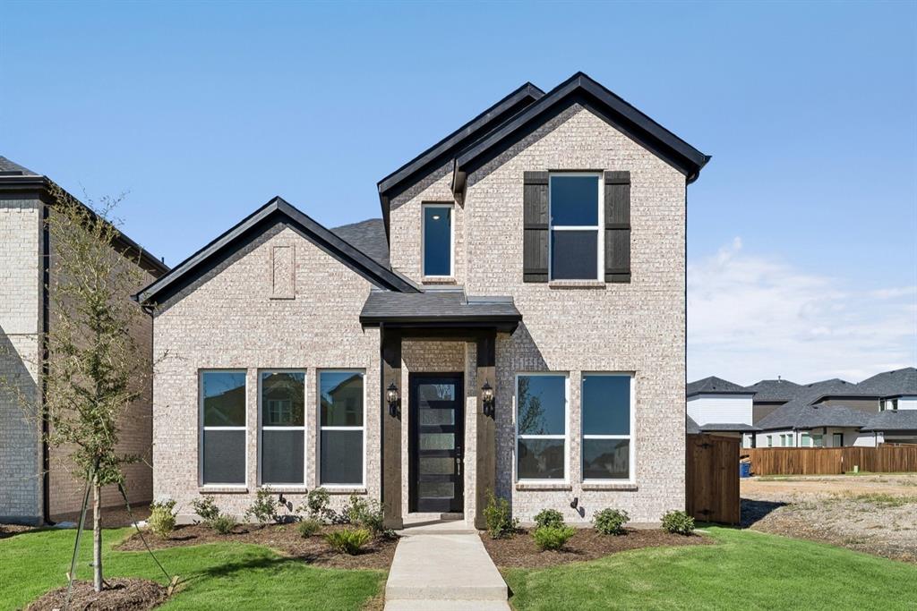 Multi-gabled exterior featuring light-toned brick masonry, dark trim accents, shuttered windows, and a modern glass-paneled entry door