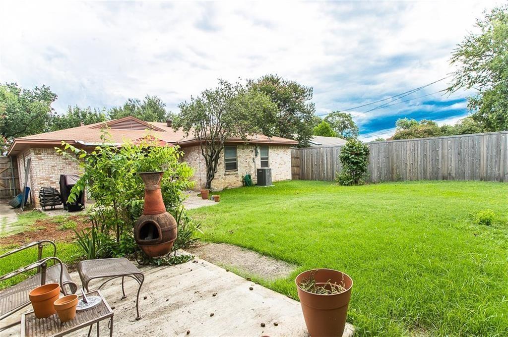 Backyard featuring a concrete patio, grassy lawn, and perimeter wood fencing
