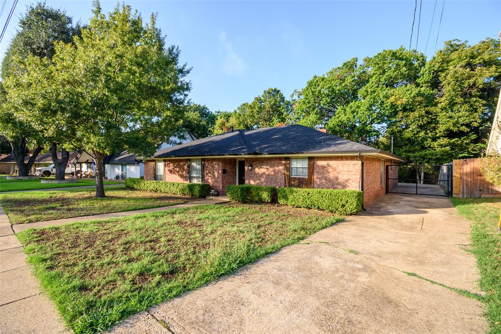 Single-story brick exterior with a dark-toned roof, concrete driveway, and established landscaping Single-story brick exterior with a dark-toned roof, concrete driveway, and established landscaping