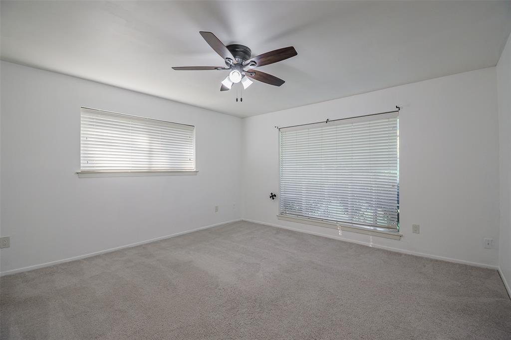Neutral-toned wall finish, wall-to-wall carpeting, ceiling fan with integrated lighting, and horizontal window blinds
