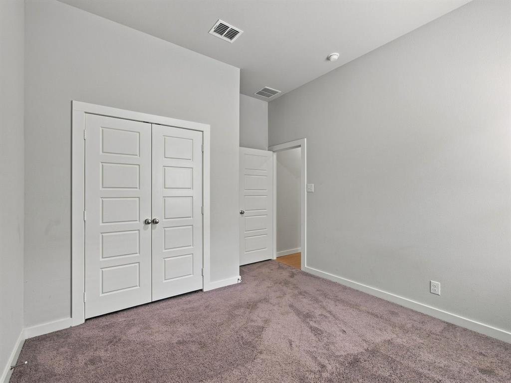 Room featuring neutral wall tones, high ceilings, carpeting, and white paneled doors