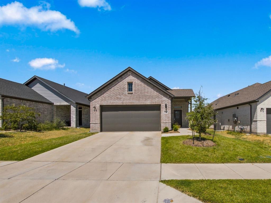 Brick exterior with gable roofline, attached multi-car garage, and concrete driveway