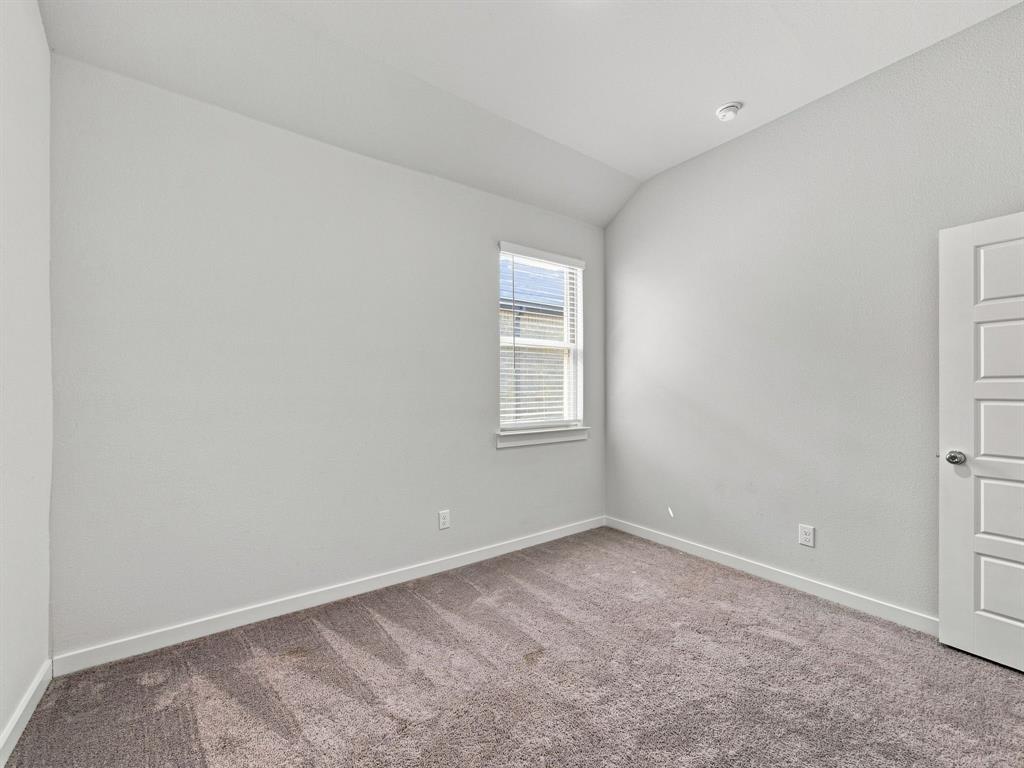 Vaulted ceilings, neutral wall color, single-pane window, and five-panel interior door with carpeted flooring