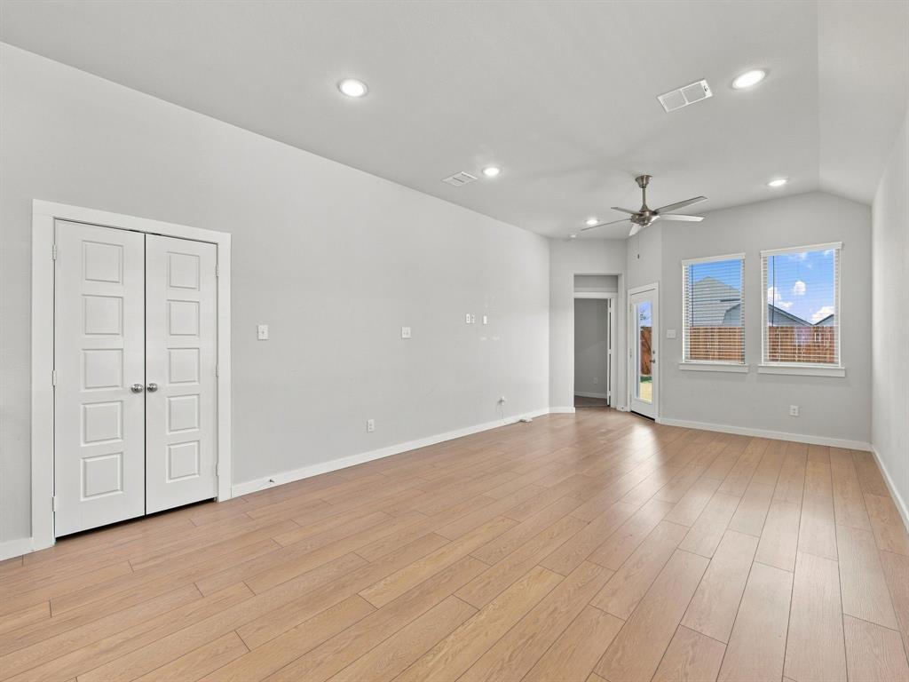 Vaulted ceilings with recessed lighting, wood-finish flooring, and double-door closet storage