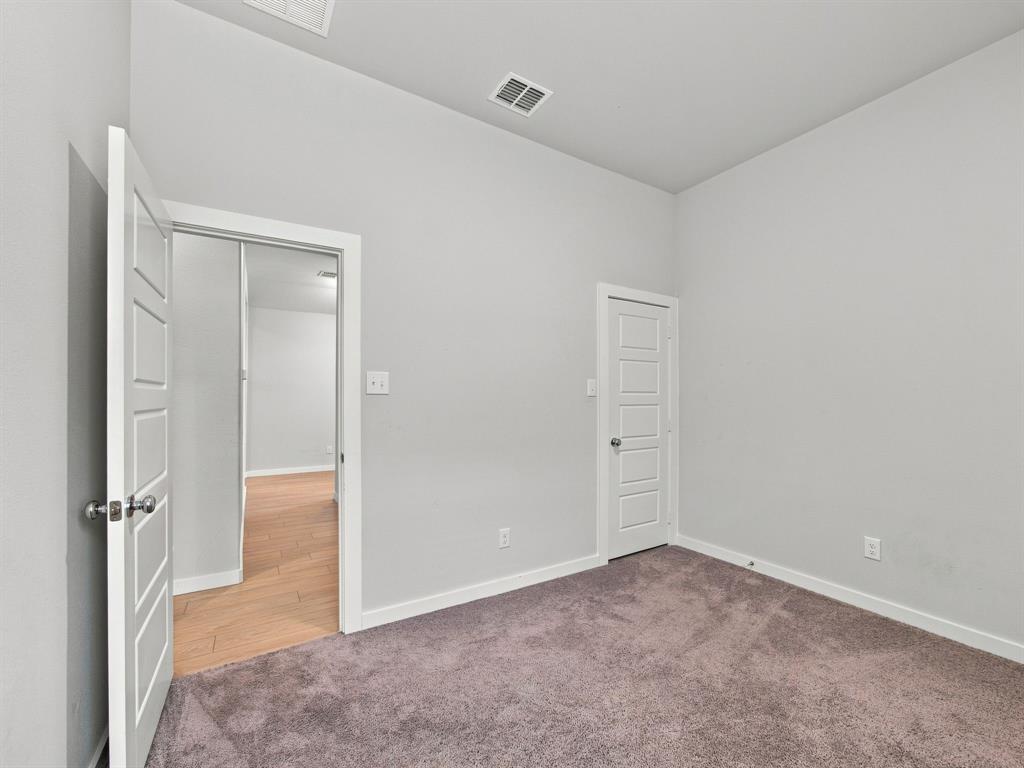 Neutral interior room featuring plush carpeting, high ceilings, and traditional-style four-panel doors