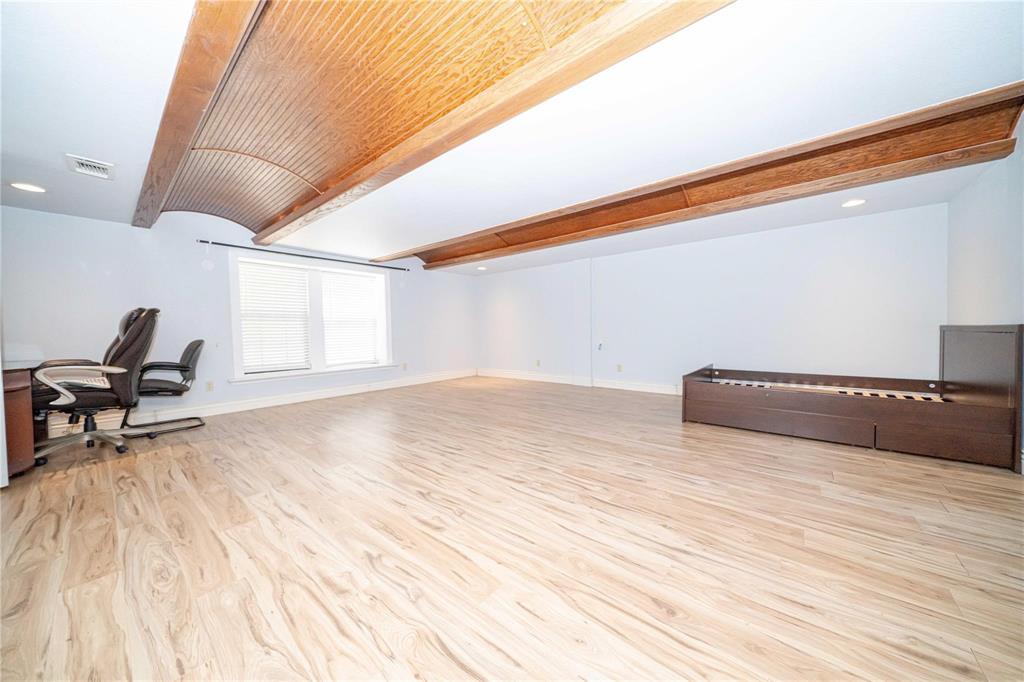 Wood-finish flooring, recessed lighting, and a prominent arched wood-plank ceiling feature