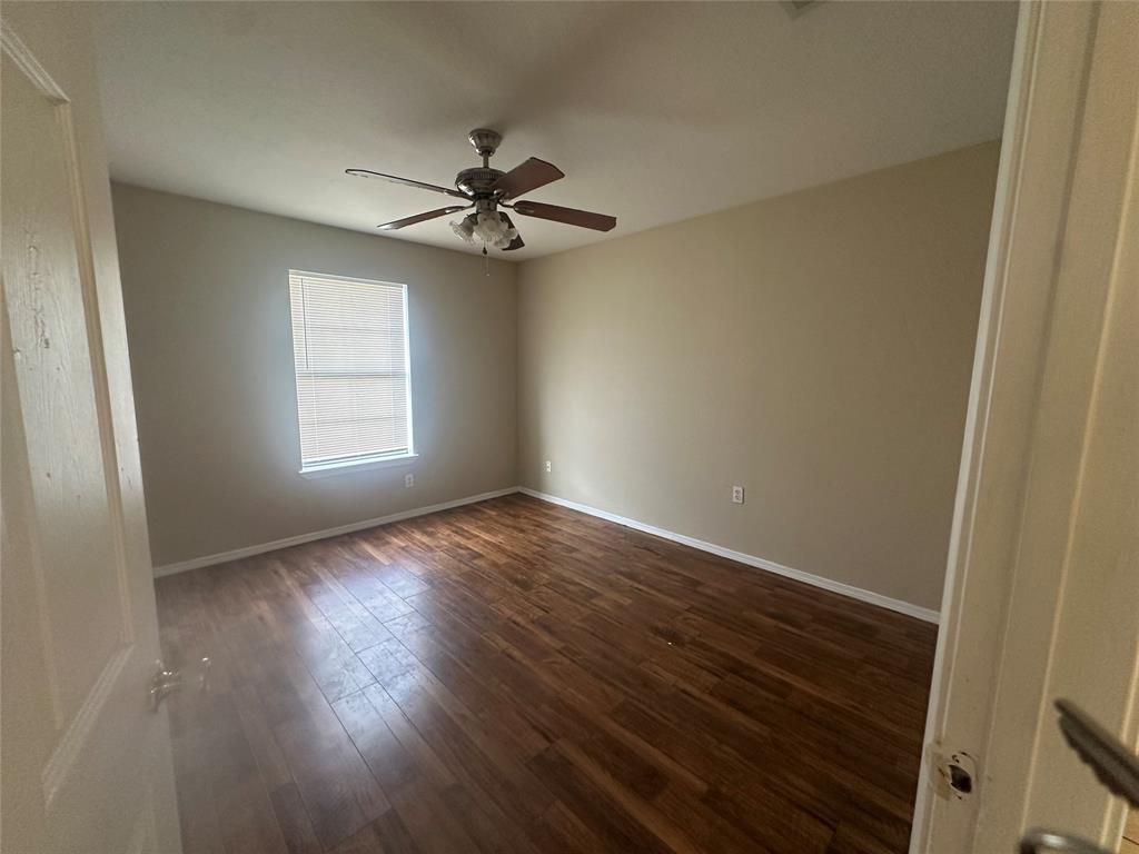 Room featuring wood-finish flooring, neutral wall paint, and a ceiling fan with integrated lighting Room featuring wood-finish flooring, neutral wall paint, and a ceiling fan with integrated lighting