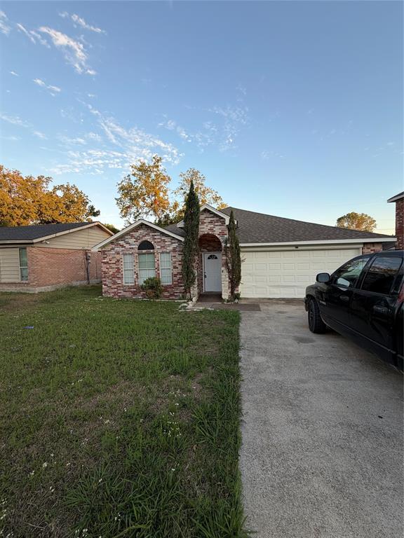 Single-story exterior featuring multi-toned masonry veneer, arched entryway, multi-pane window detail, and an attached two-car garage