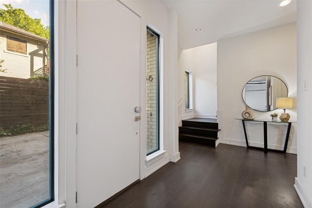 Entryway featuring dark wood-finish flooring, recessed lighting, expansive vertical windows, and a tall solid-core entrance door
