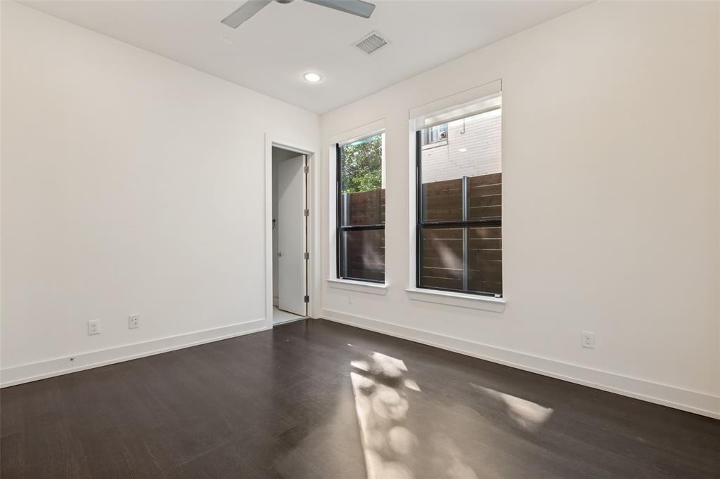 Room featuring dark wood-finish flooring, high ceilings with recessed lighting, a ceiling fan, and dual windows with black frames