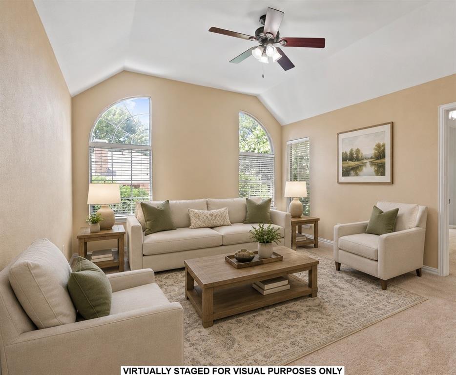 Vaulted ceilings, arched windows, and a multi-blade ceiling fan with integrated lighting