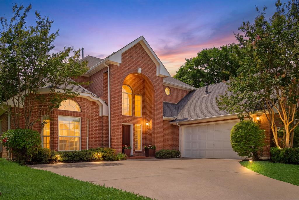 Red brick exterior featuring an arched entryway, gabled roofline, multi-pane arched windows, and a concrete driveway Red brick exterior featuring an arched entryway, gabled roofline, multi-pane arched windows, and a concrete driveway