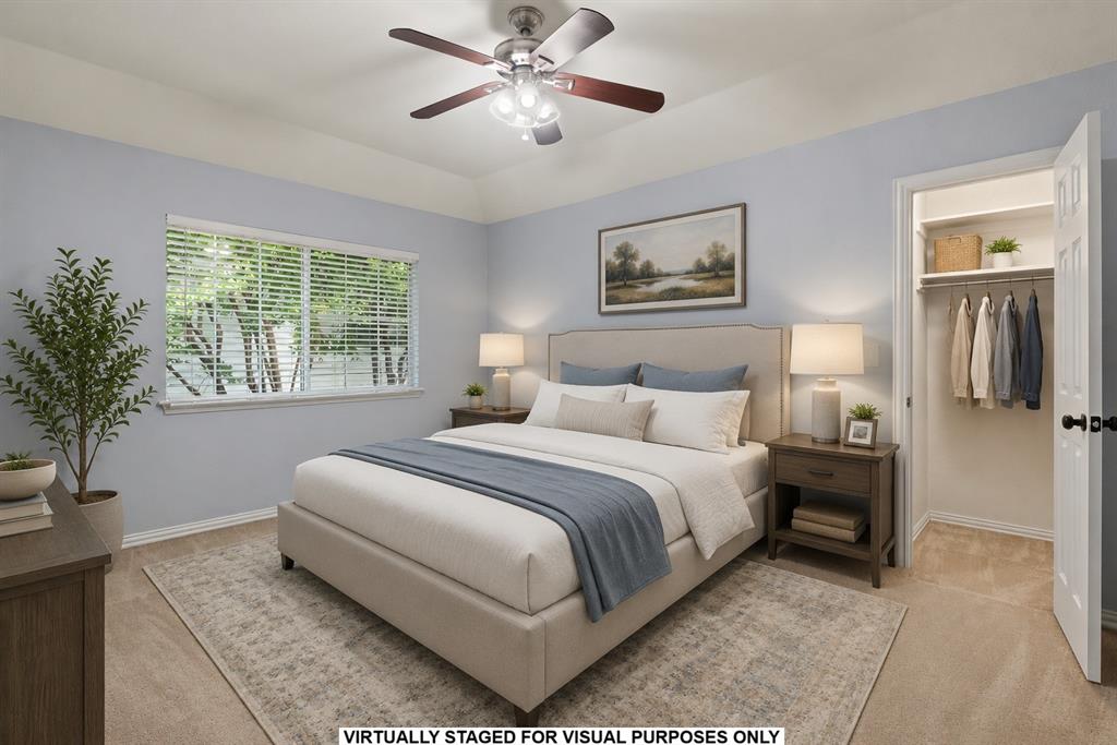 Bedroom featuring a tray ceiling, ceiling fan with integrated lighting, wall-to-wall carpeting, horizontal window blinds, and a built-in closet