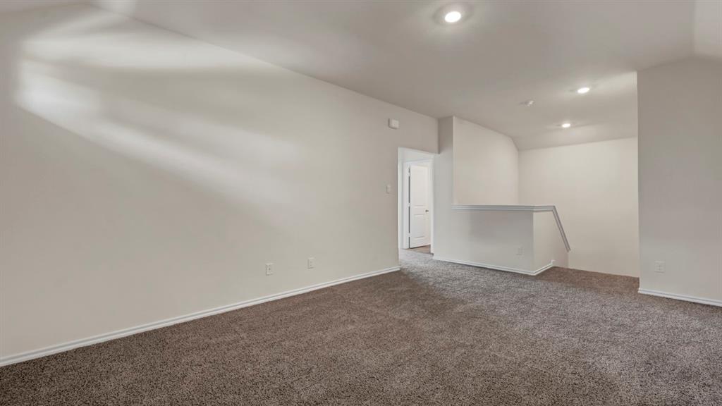Open area with wall-to-wall carpeting and recessed lighting