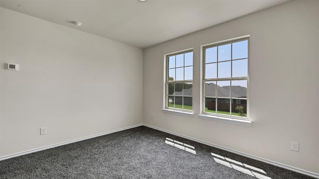Neutral wall paint, two grid-pattern windows, recessed ceiling lighting, and dark gray carpeting