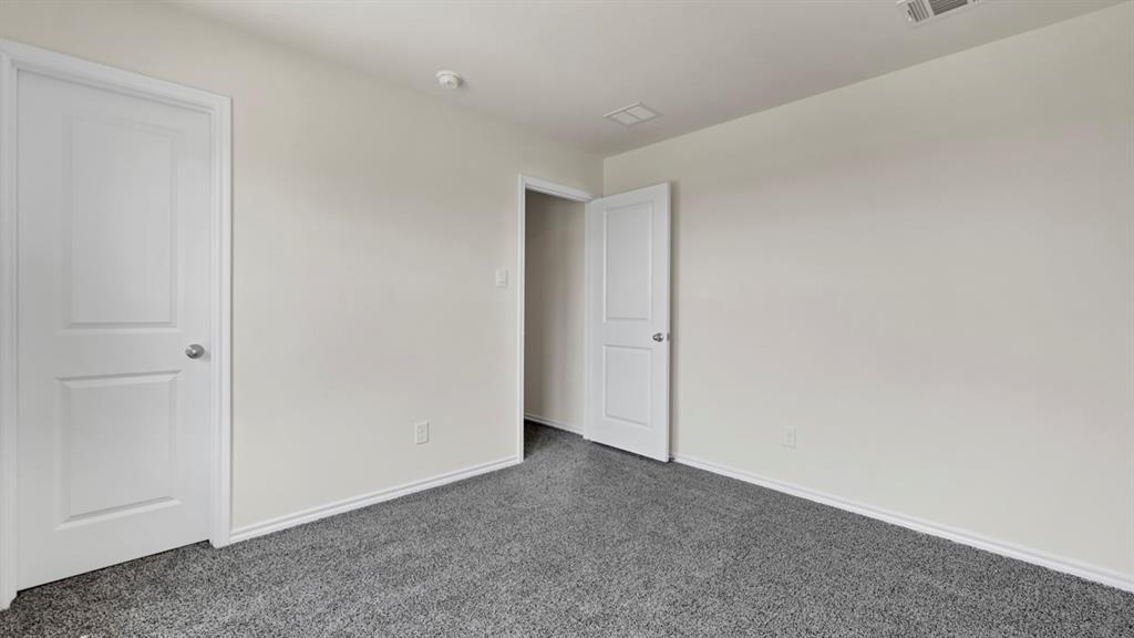 Gray carpeted flooring with white baseboards, light-toned walls, and white paneled doors