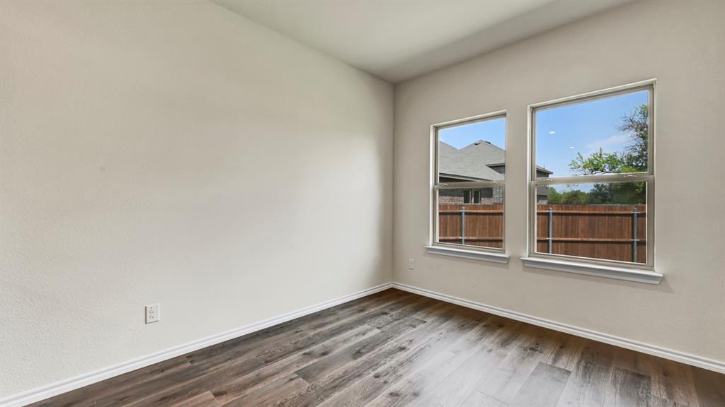 Wood-finish flooring with white baseboards, two single-hung windows, and light-colored wall paint Wood-finish flooring with white baseboards, two single-hung windows, and light-colored wall paint