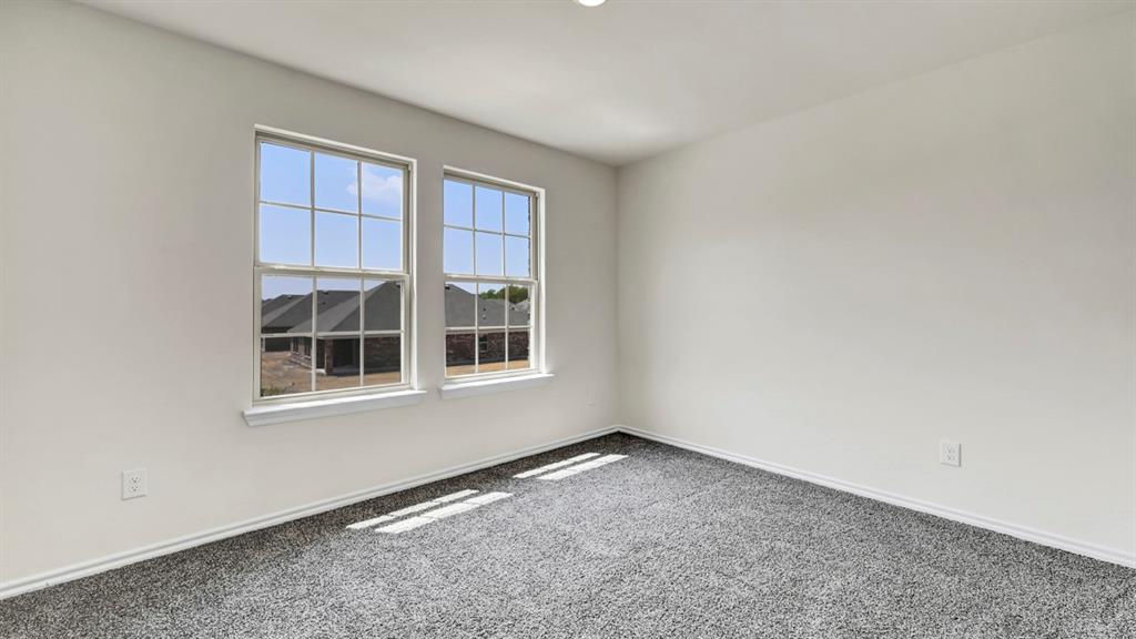 Neutral wall tones, recessed ceiling lighting, two double-hung windows, and grey carpeted flooring