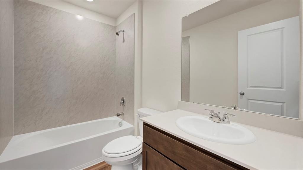White bathtub with gray-patterned surround and chrome fixtures White bathtub with gray-patterned surround and chrome fixtures