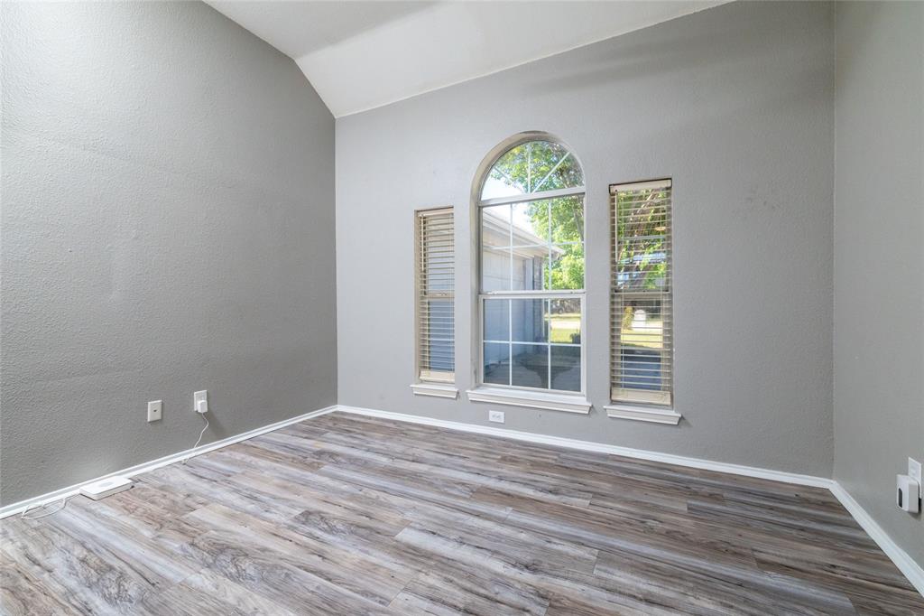 Vaulted ceilings featuring an arched window flanked by rectangular windows, finished with wood-finish flooring Vaulted ceilings featuring an arched window flanked by rectangular windows, finished with wood-finish flooring