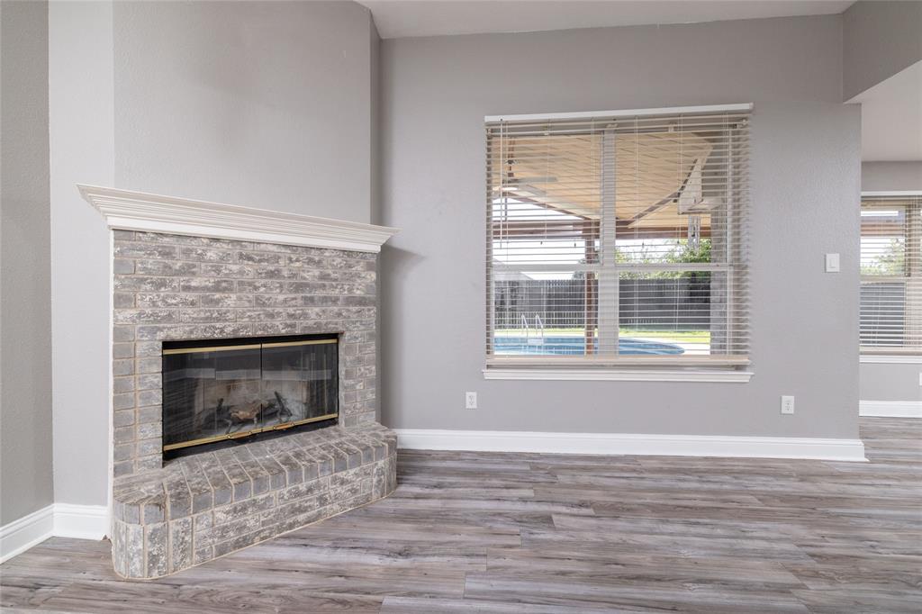 Fireplace with stone-finish masonry, elevated hearth, and white crown molding surround, paired with wood-finish flooring