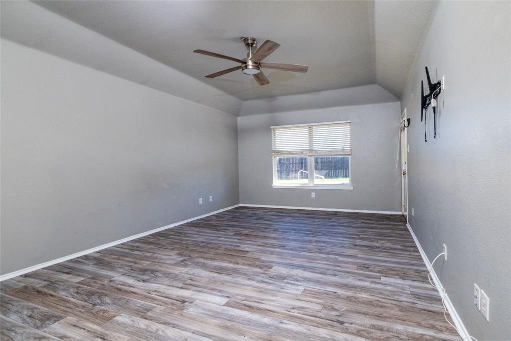 Trey ceiling featuring a central brushed-nickel ceiling fan, light-toned wood-finish flooring, and horizontal window blinds