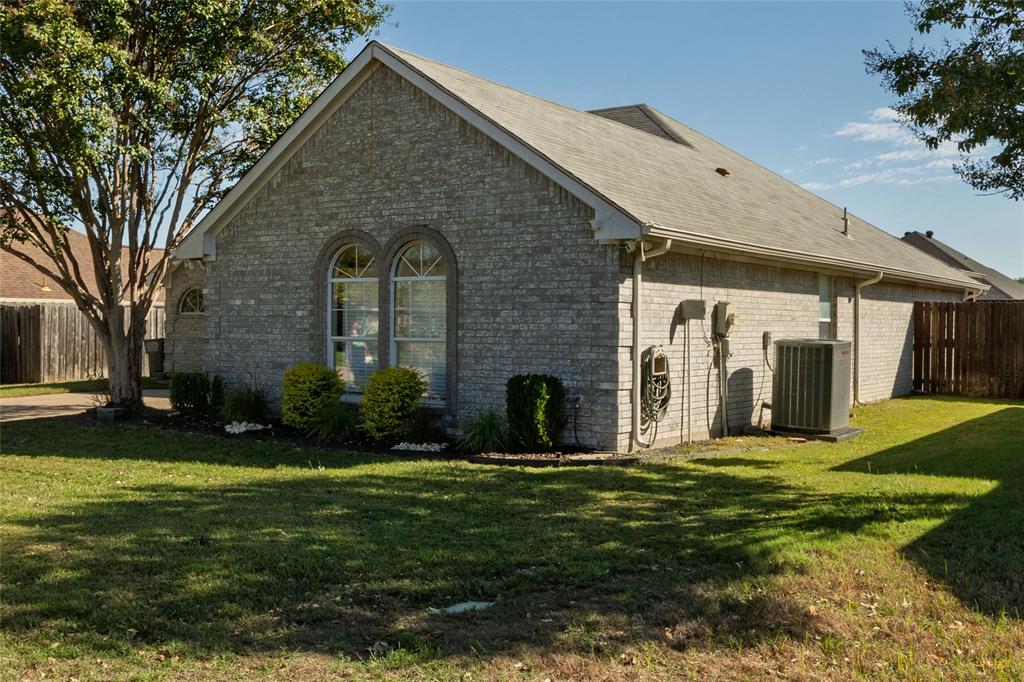Brick exterior featuring a gabled roofline, arched windows with masonry detailing, and professional landscaping Brick exterior featuring a gabled roofline, arched windows with masonry detailing, and professional landscaping
