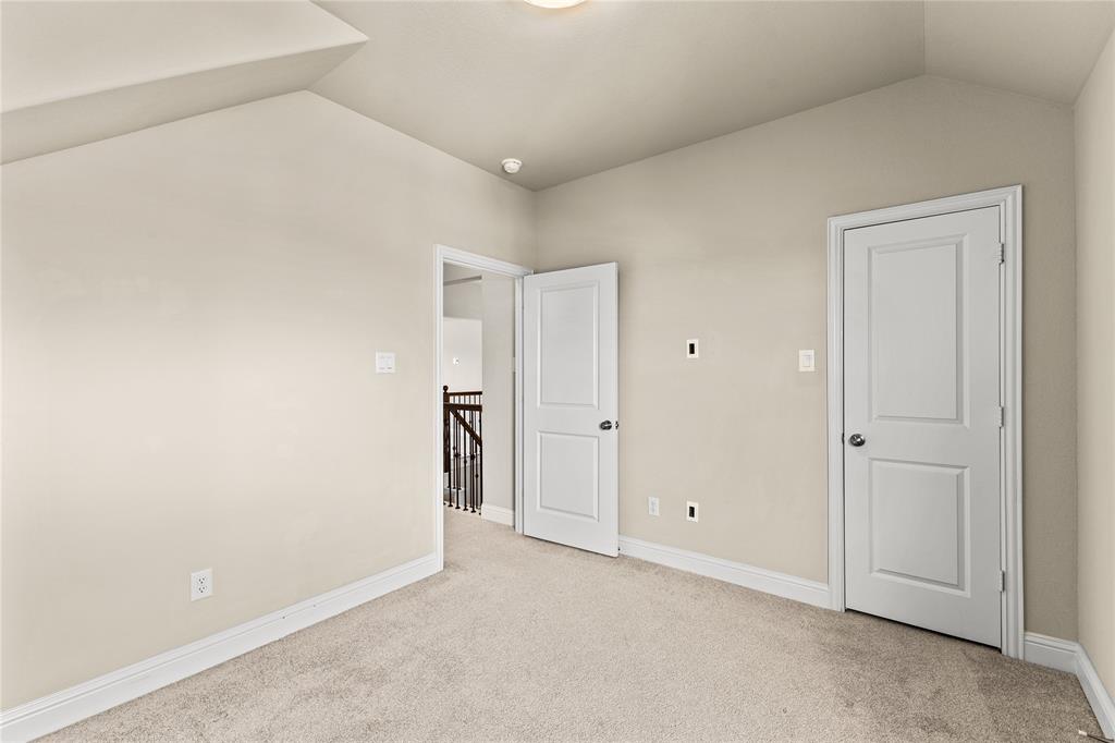 Vaulted ceiling, neutral wall tones, wall-to-wall carpeting, and two-panel interior doors