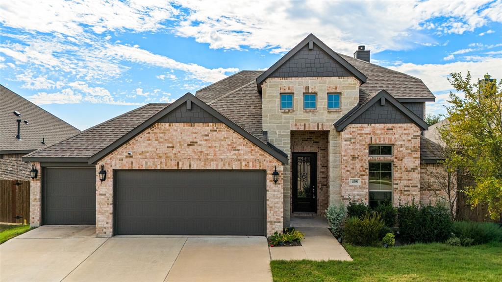 Multi-gabled exterior featuring light brick masonry, decorative shingle siding, a multi-car garage, and a recessed entryway with a glass-paneled door Multi-gabled exterior featuring light brick masonry, decorative shingle siding, a multi-car garage, and a recessed entryway with a glass-paneled door