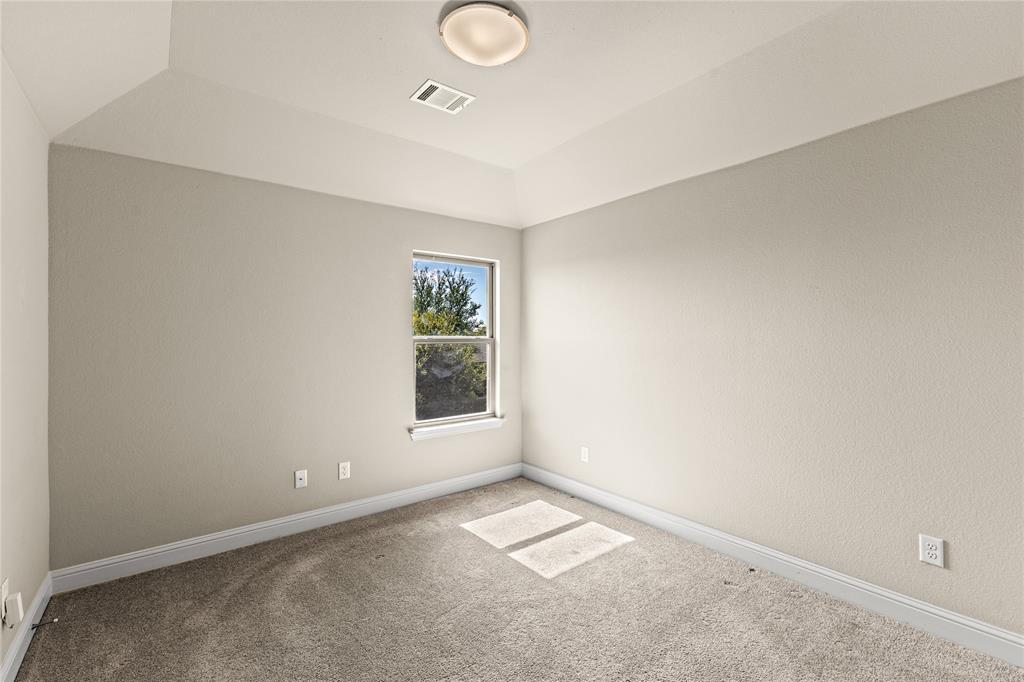 Interior room featuring a tray ceiling, neutral wall tones, neutral wall-to-wall carpeting, and a single window