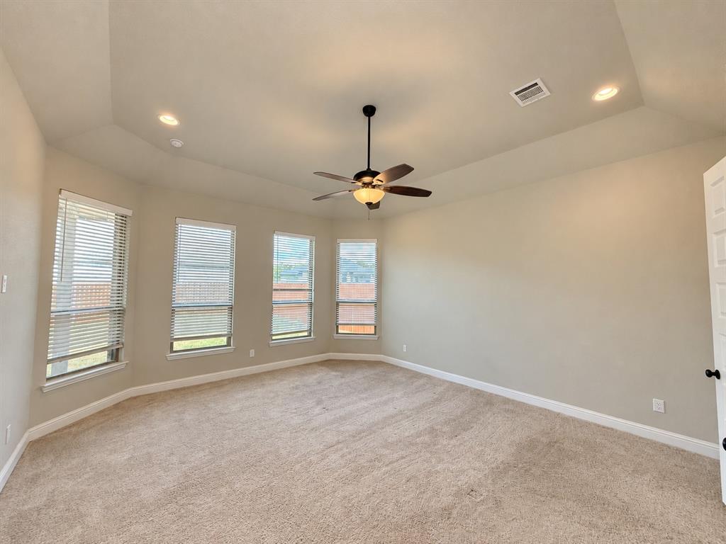 Vaulted ceilings featuring recessed lighting and a central ceiling fan, expansive windows, and neutral carpeting