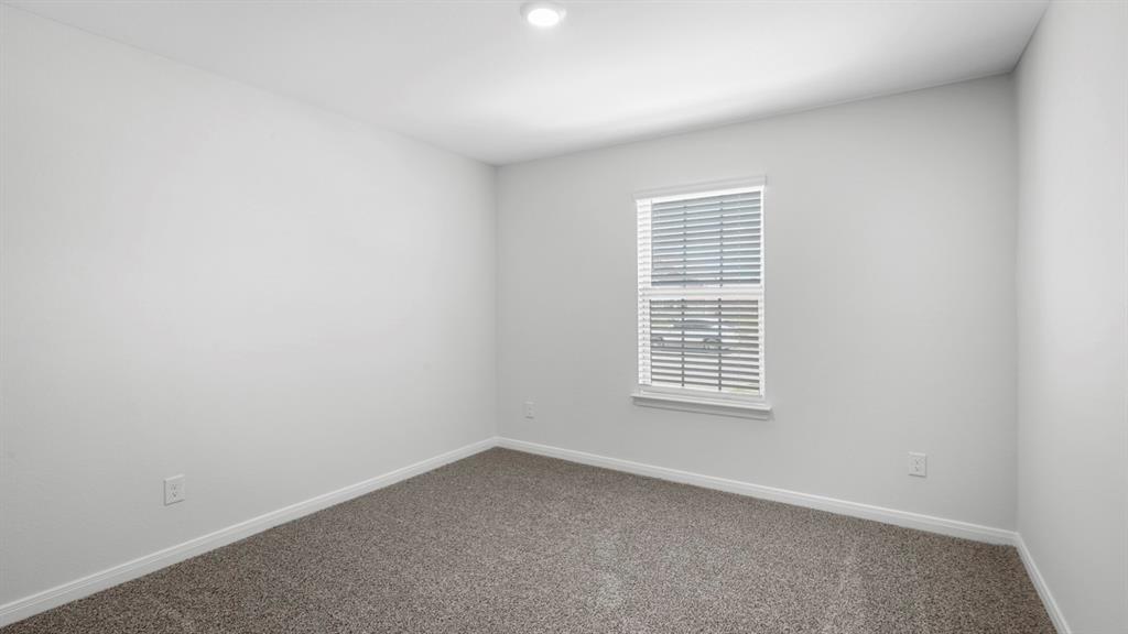 Neutral wall color with baseboard trim, recessed ceiling lighting, textured carpet, and a window featuring horizontal blinds