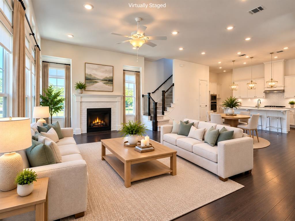 Open-concept floor plan, high ceilings, large windows, dark grand flooring, and a fireplace.