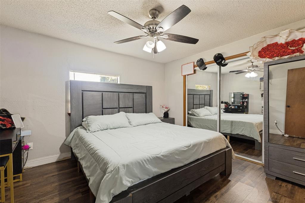 Wood-finish flooring, ceiling fan with integrated lighting, and dual sliding mirrored closet doors