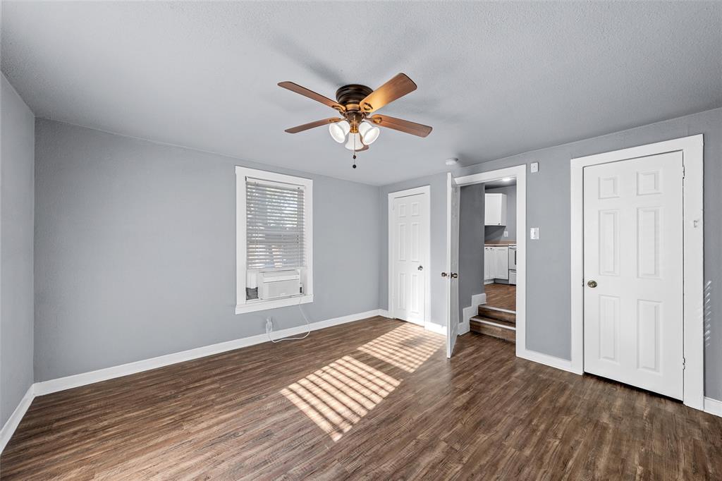Wood-finish flooring, multi-panel doors, neutral wall paint, and a ceiling fan with integrated lighting Wood-finish flooring, multi-panel doors, neutral wall paint, and a ceiling fan with integrated lighting