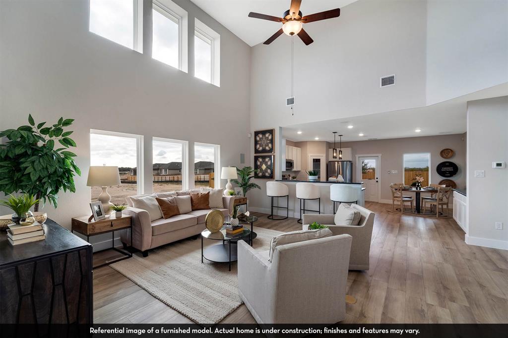 Expansive living area featuring vaulted ceilings, floor-to-ceiling windows, wood-finish flooring, a ceiling fan, and recessed lighting