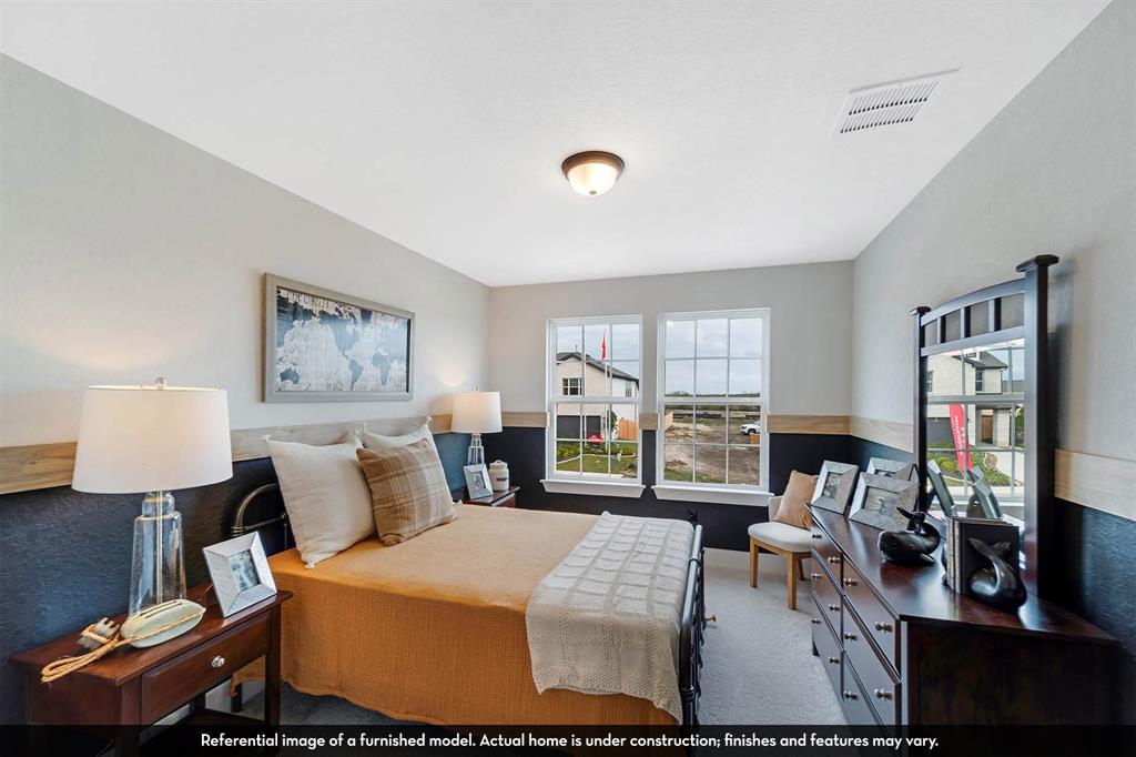 Dual-tone interior walls featuring wood trim detailing, neutral carpeting, and two double-pane windows