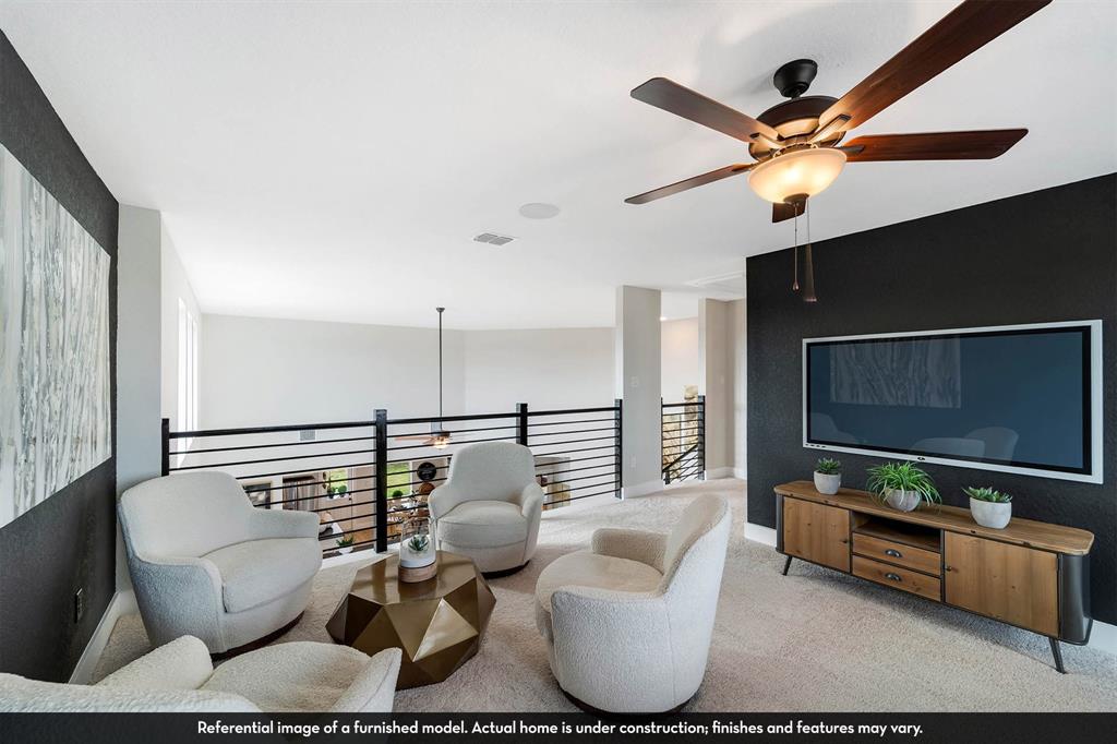 Open-concept area featuring a metal horizontal-bar railing, a dark accent wall, and a ceiling fan with integrated lighting