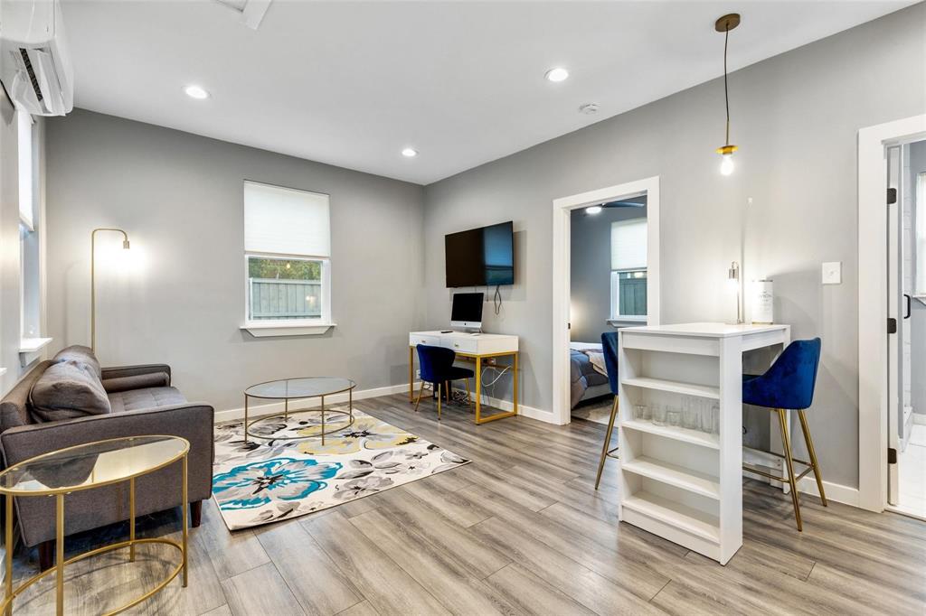Wood-finish flooring, recessed lighting, wall-mounted air conditioning unit, and pendant lighting