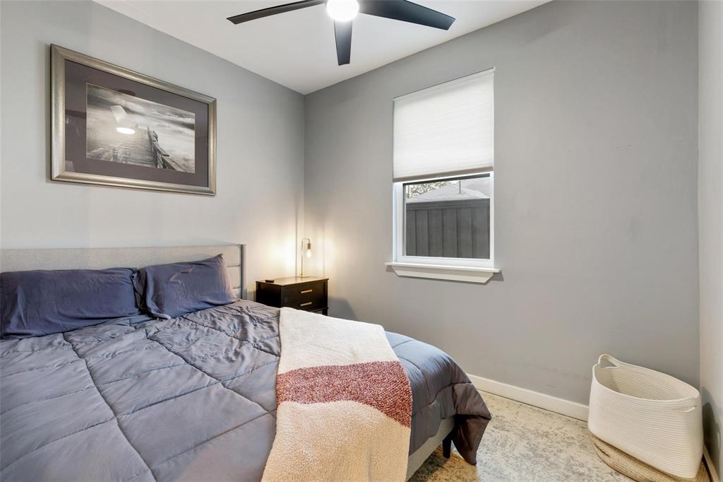 Neutral-toned interior walls, cellular window shade, and matte black ceiling fan