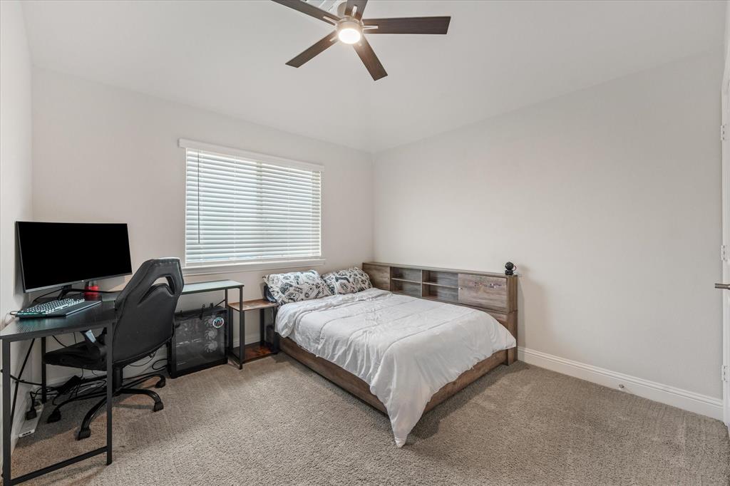 Bedroom 2 featuring neutral-toned carpeting, a ceiling fan with integrated lighting, and a window with horizontal blinds