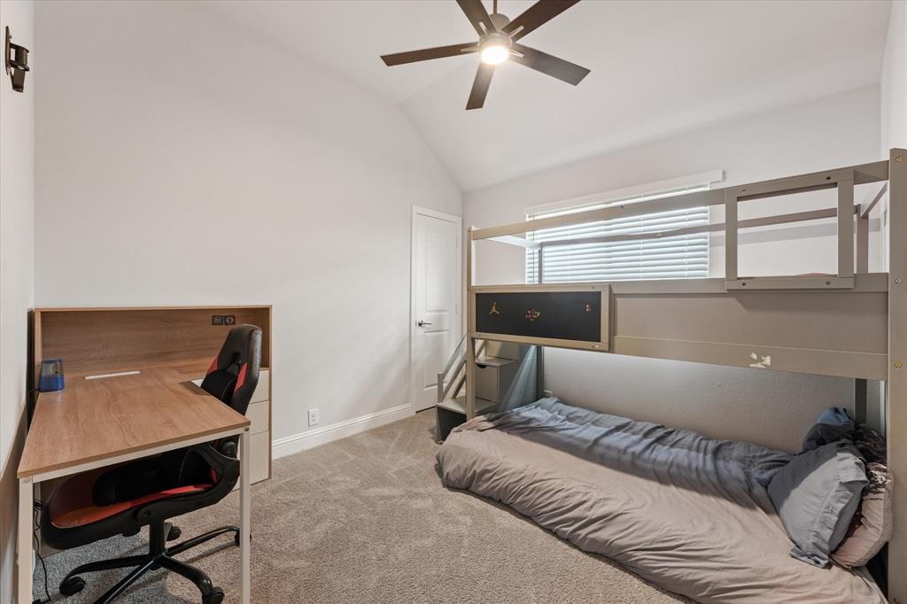 Bedroom 3 Vaulted ceiling featuring a central multi-blade ceiling fan, wall-to-wall carpeting, and a multi-pane window with horizontal blinds