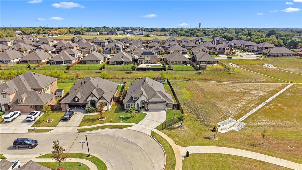Aerial perspective showcasing a suburban residential area with concrete cul-de-sac streets, paved sidewalks, and extensive open green space