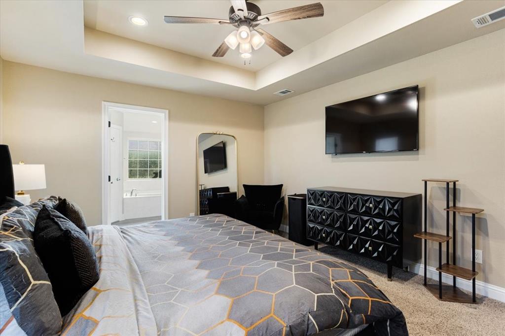 Tray ceiling featuring recessed lighting and a central ceiling fan with multi-light fixture