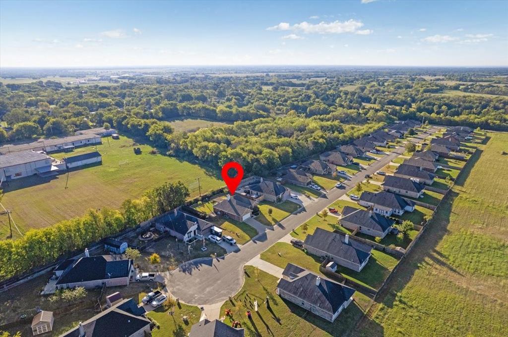 Aerial perspective of a single-story residence situated on a cul-de-sac lot, featuring a shingled roof, attached garage, and fenced perimeter
