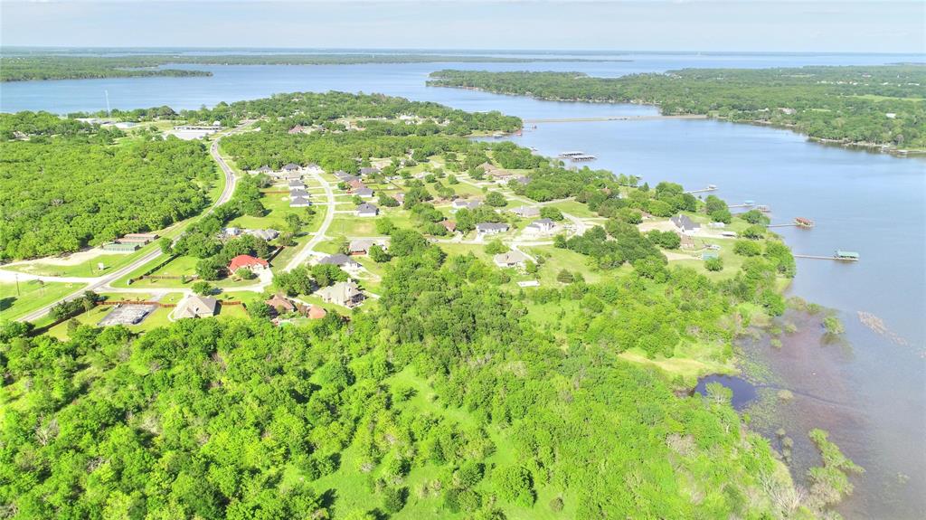 Aerial overview of property's location featuring a nearby body of water and a heavily wooded area