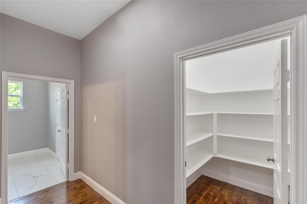 Hallway featuring dark wood-style floors and baseboards