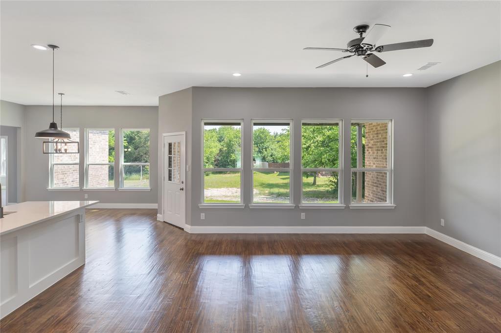 Unfurnished living room featuring dark wood-style floors, plenty of natural light, a ceiling fan, and recessed lighting